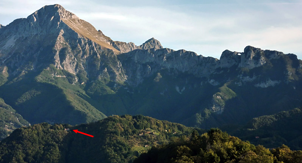 Panorama delle Alpi Apuane con una freccia rossa che indica la posizione dell’Osservatorio
